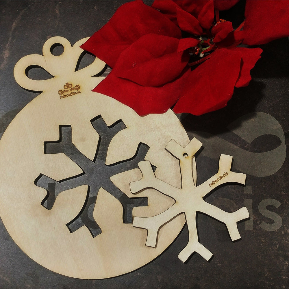 Boule de noël en bois découpé au laser, avec une forme de flocon.