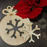 Boule de noël en bois découpé au laser, avec une forme de flocon.